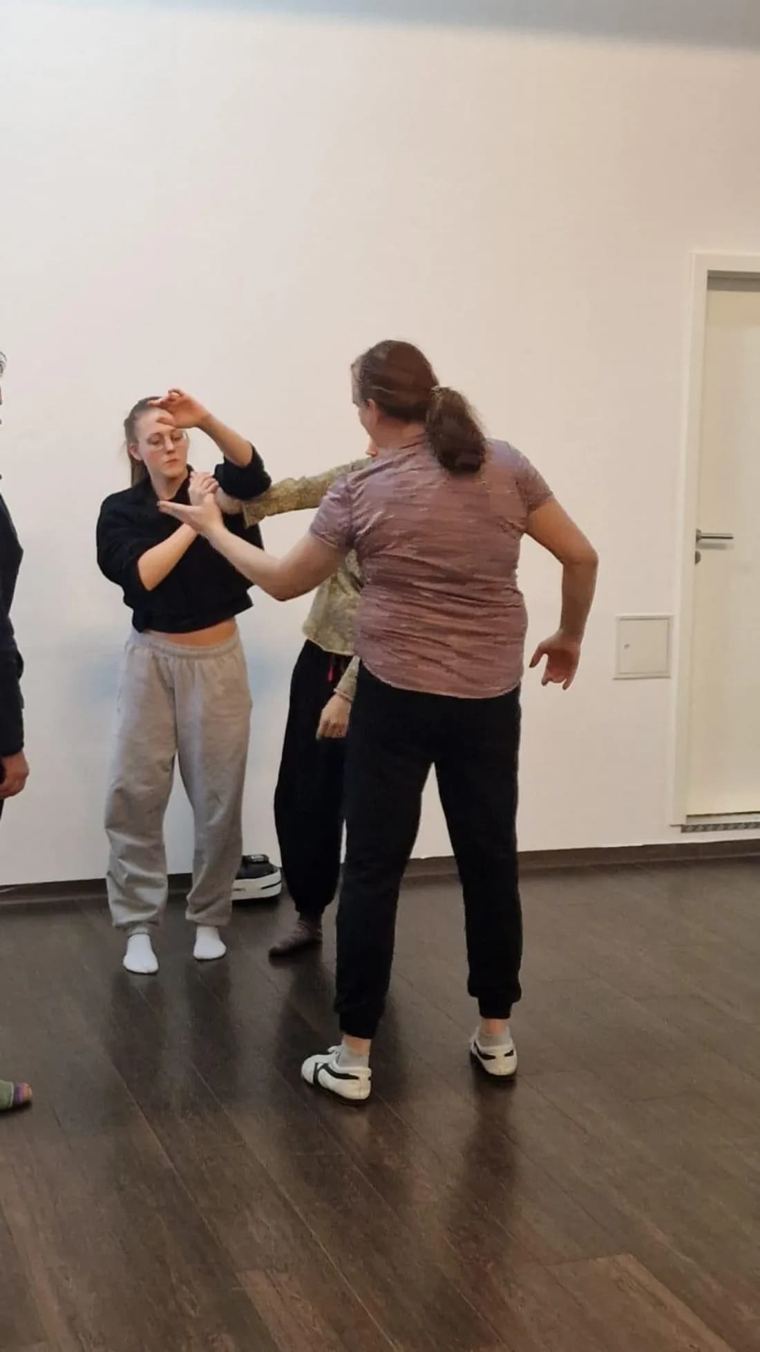 Eine Gruppe übt gemeinsam, sich aus einem Handgelenkgriff zu lösen.